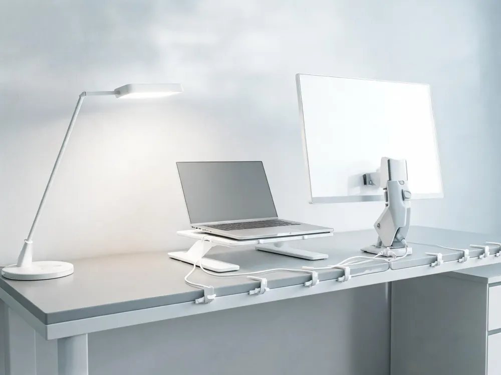 Cable clips, an adjustable laptop stand, a monitor arm, and a smart lamp, illustrating a tidy and motivating workspace.