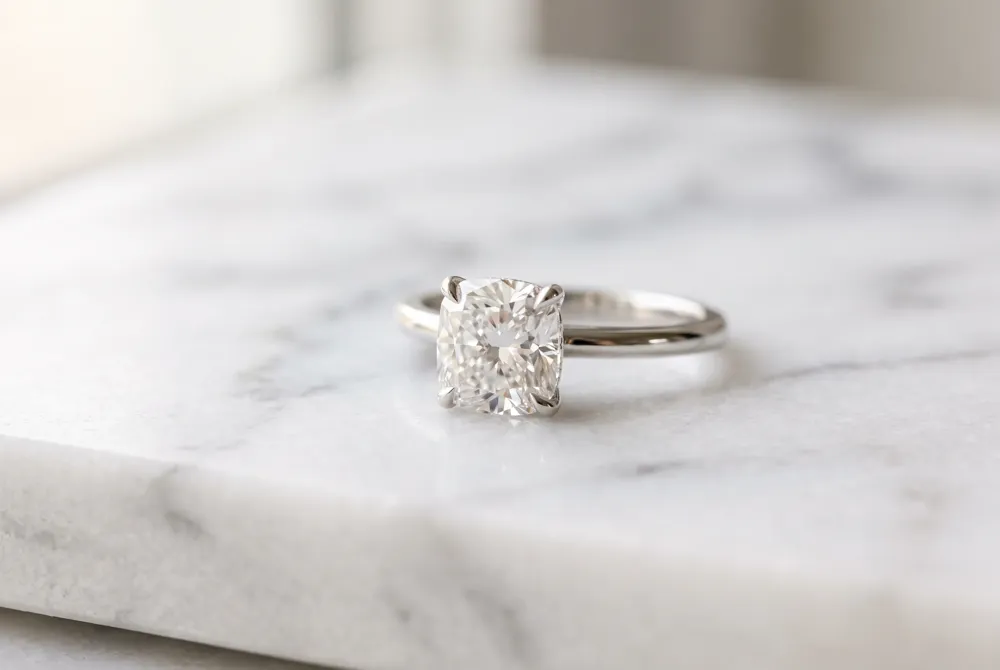 The classic solitaire setting celebrates the inherent grace of the cushion cut by highlighting its soft silhouette and brilliant light performance.