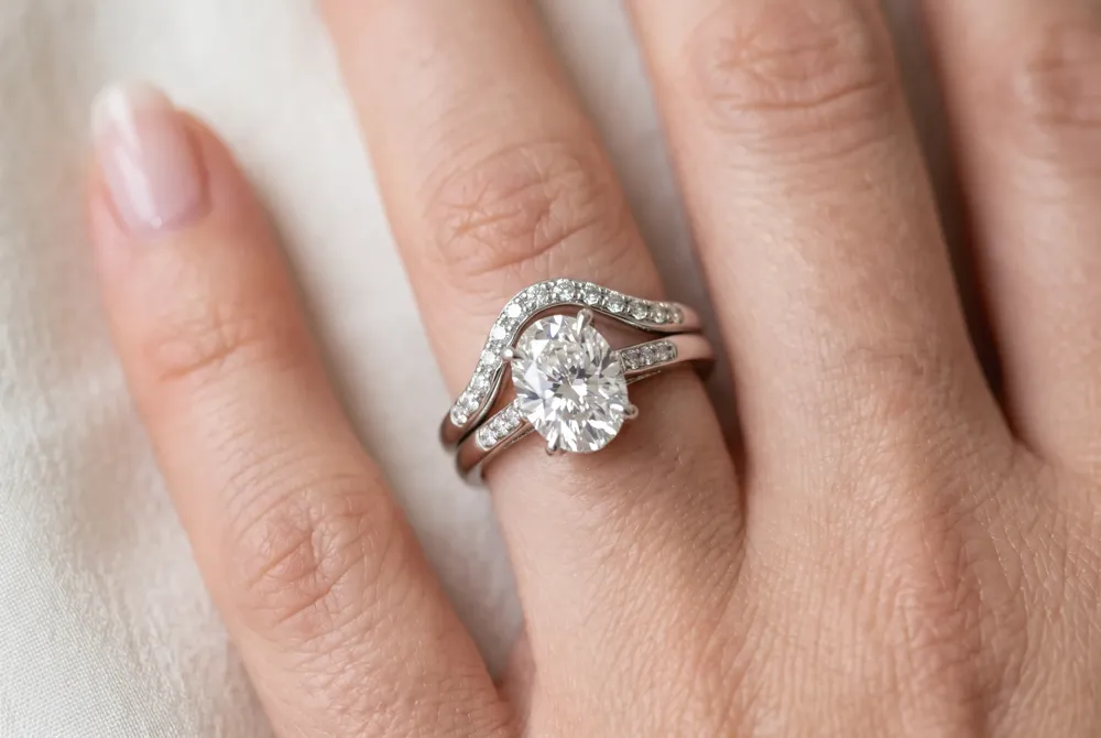 A contour wedding band, famously worn by Taylor Swift, curves to fit flush against your engagement ring, creating a unified and seamless stack.