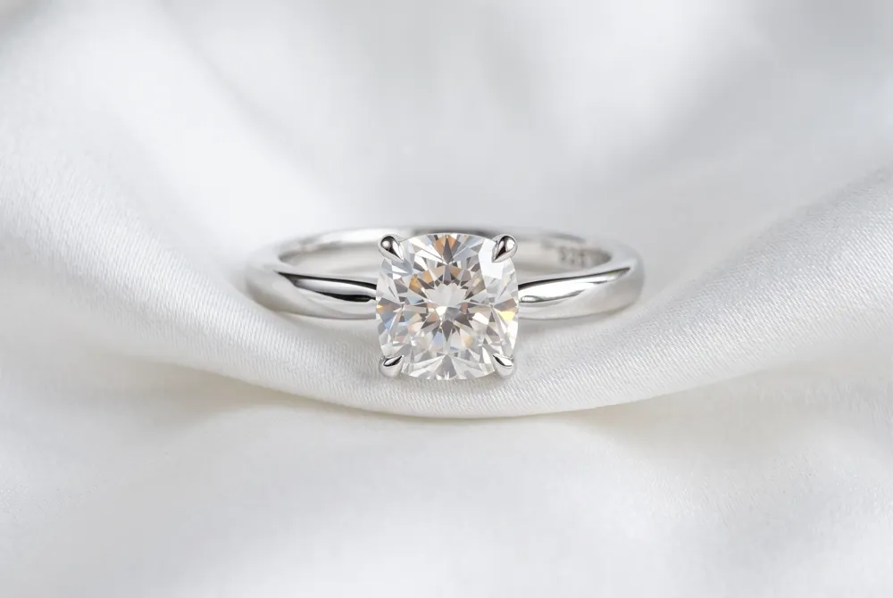 Embrace the pure, unfiltered beauty of your cushion cut moissanite with a solitaire setting designed to let its soft, romantic sparkle take center stage without distraction.