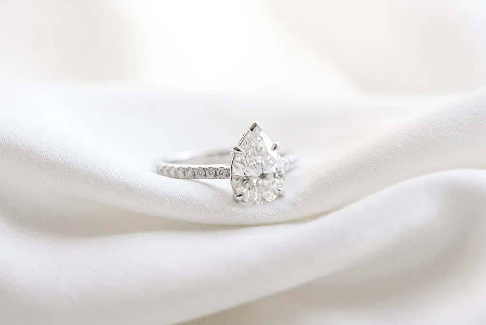 Discover the art of pairing your pear shaped ring with contoured bands to highlight its graceful geometry and create a timeless, harmonious bridal ensemble.