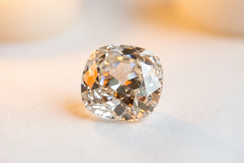 An antique old mine brilliant cut diamond with a soft candlelit glow.