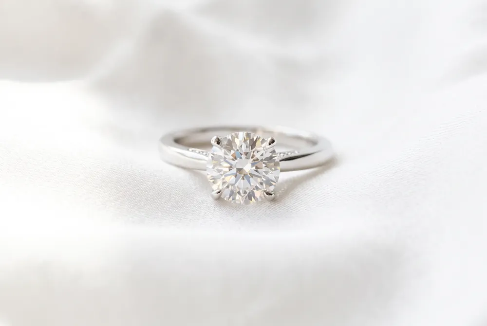 Discover the subtle brilliance of a hidden halo that provides an enchanting, unexpected glimmer beneath your sophisticated cushion cut.