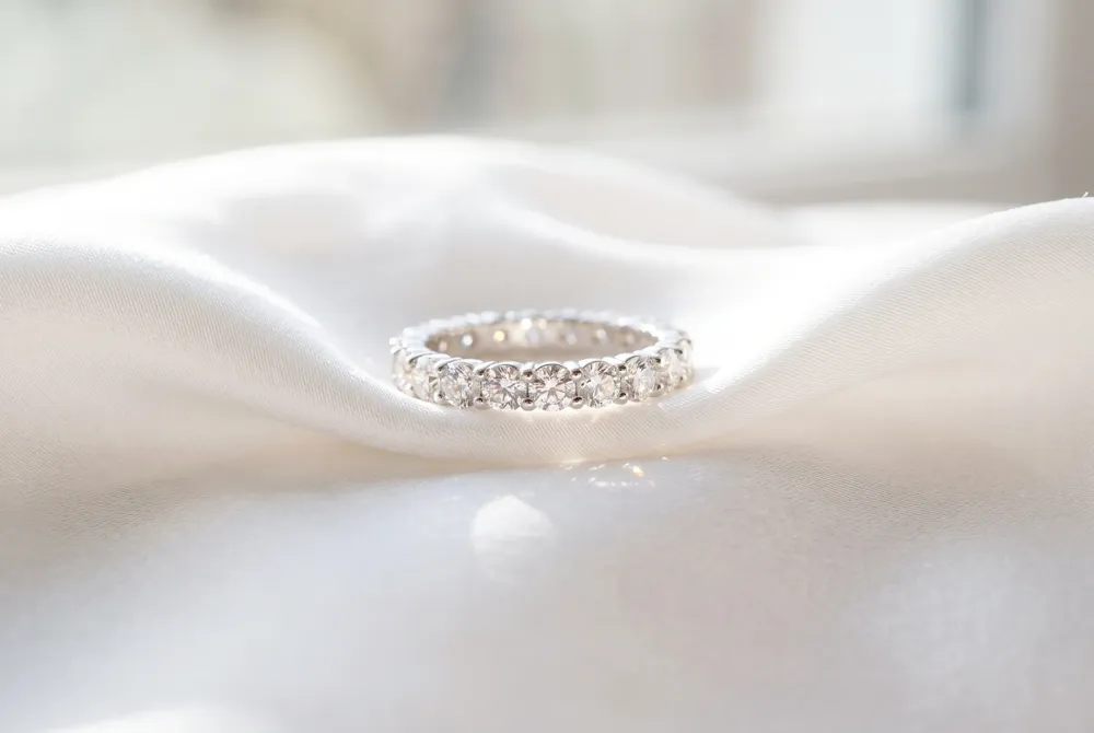 The classic round brilliant eternity band serves as a timeless, radiant foundation for your refined bridal collection.
