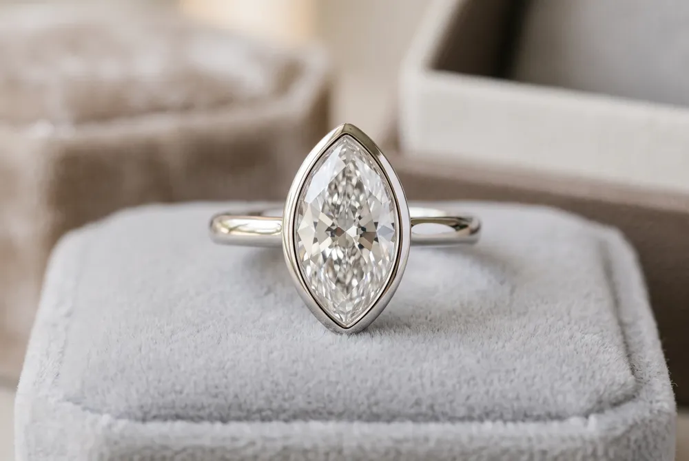 A continuous metal rim shields the marquise diamond's vulnerable tips, creating a sleek, uninterrupted silhouette that offers both security and refined style.