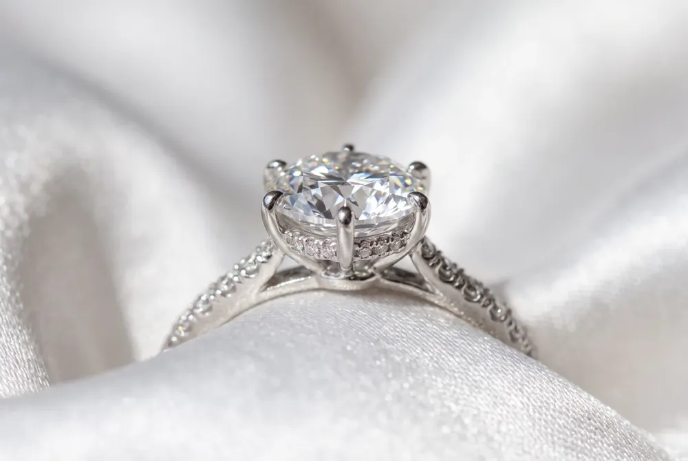The hidden halo tucks a secret ring of smaller stones beneath the center gem, adding a whisper of brilliance and a gentle surprise for those who notice.