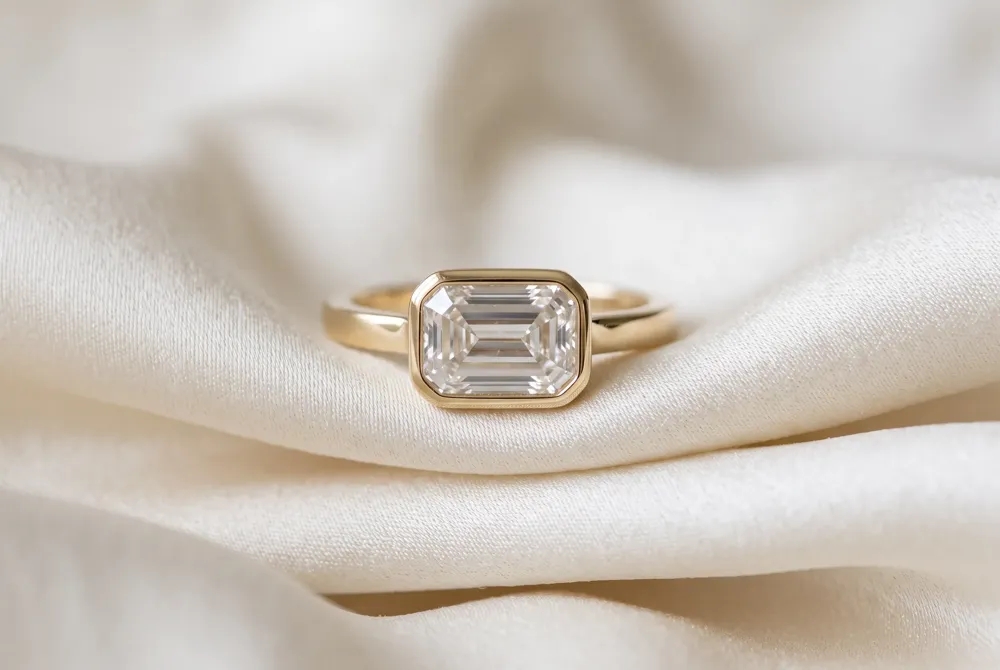 An east-west bezel setting flatters the elongated cushion's soft outline, offering a modern, protective frame that lets the stone's brilliance shine while adding an effortlessly editorial edge.