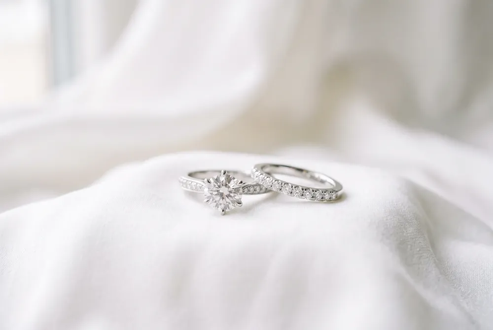 Tradition suggests placing the wedding band closest to the heart to honor the foundation of your union, with the engagement ring resting elegantly above.