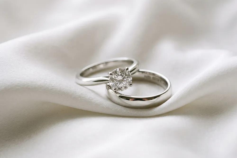 Where the engagement ring's center stone shines as a bold promise, the wedding band's unbroken circle quietly embodies the eternal commitment of your vows.
