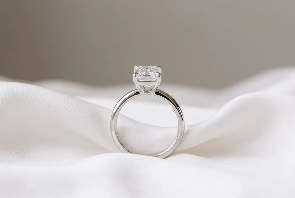 A sleek, straight band beautifully echoes the emerald cut's refined lines, letting the center stone remain the quiet star of the ring.