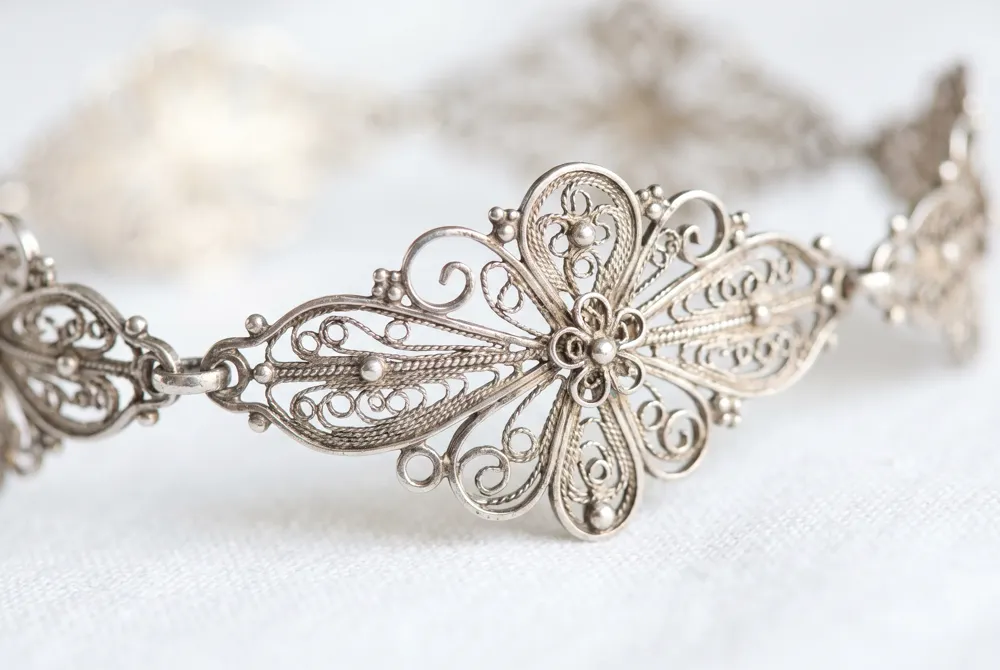 Discover the romance of history through intricate milgrain and filigree artistry that beautifully frames the modern precision of a square-cut stone.