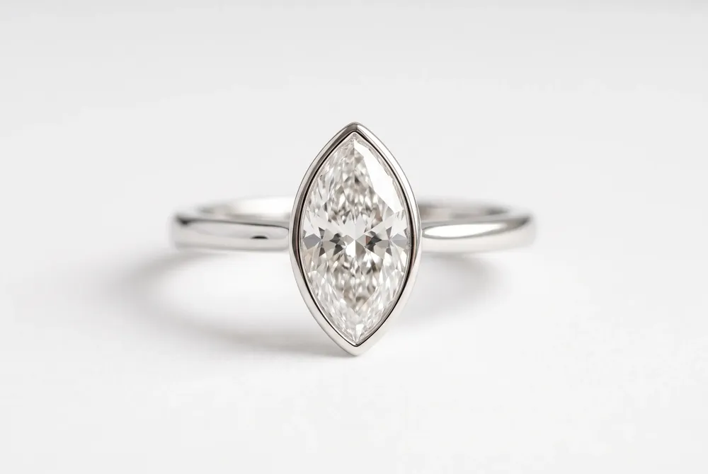 A slim metal rim encircles the entire diamond to protect the marquise’s delicate tips while delivering a sleek, contemporary profile.