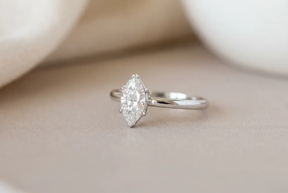 The classic north-south orientation places the marquise cut vertically along the finger, creating a lengthening effect that enhances understated elegance.