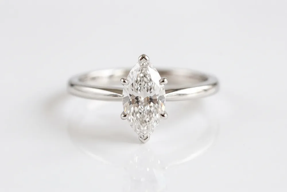 A classic solitaire setting lets the marquise diamond's full silhouette command attention, with a thin band enhancing its graceful vertical line and finger-lengthening effect.