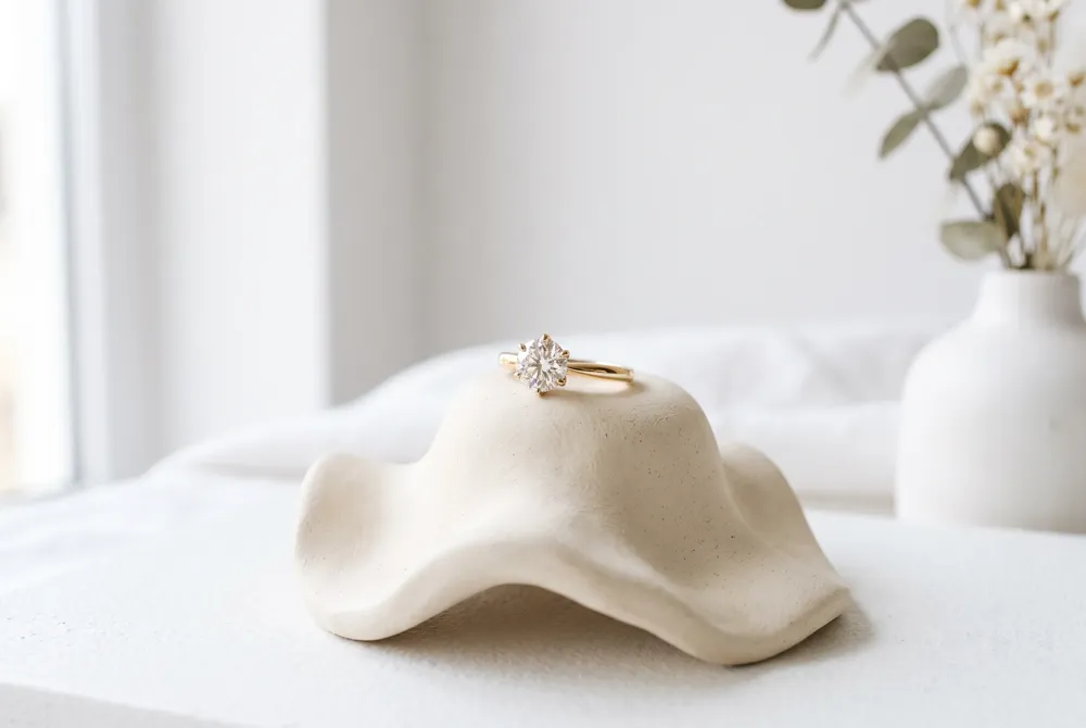 A petite solitaire lets thoughtful proportions, warm gold, and a carefully chosen setting take center stage.
