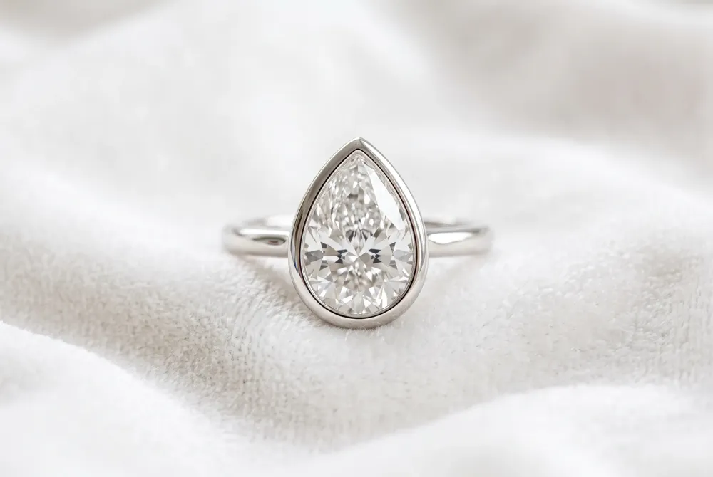 The modern bezel setting offers a seamless and secure border that protects your pear-cut diamond with sleek, contemporary sophistication.