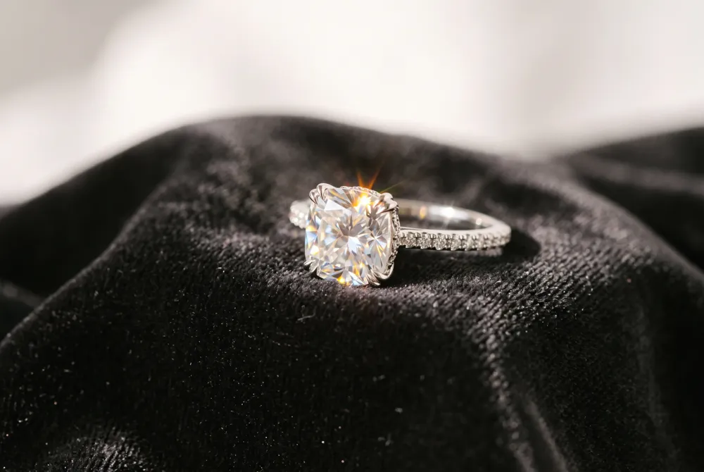 Moissanite's exceptional fire and brilliance, framed by the cushion's large facets, deliver a vintage sparkle that often outshines a traditional diamond.