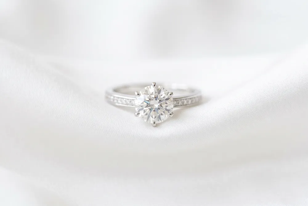 Achieve perfect symmetry and sophisticated sparkle with a three-stone setting that beautifully balances a fiery princess cut centerpiece with radiant diamond accents.