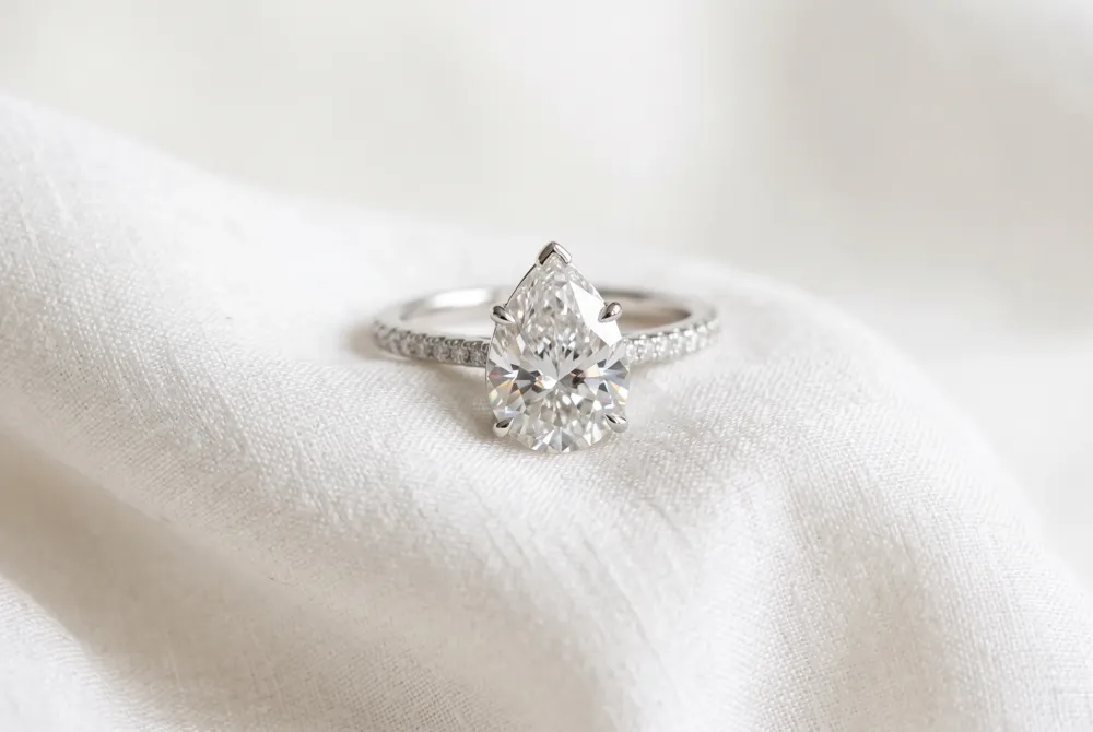 Embrace the timeless romance of a vintage-inspired halo designed to frame your pear shaped stone with unparalleled grace and shimmering brilliance.