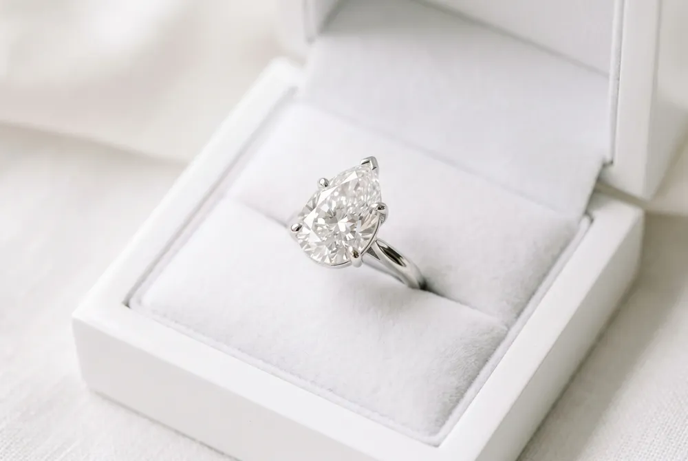 Selecting a pear-shaped engagement ring requires attention to length-to-width ratio, bow-tie effect, color, clarity, and symmetry for the most flattering fit.