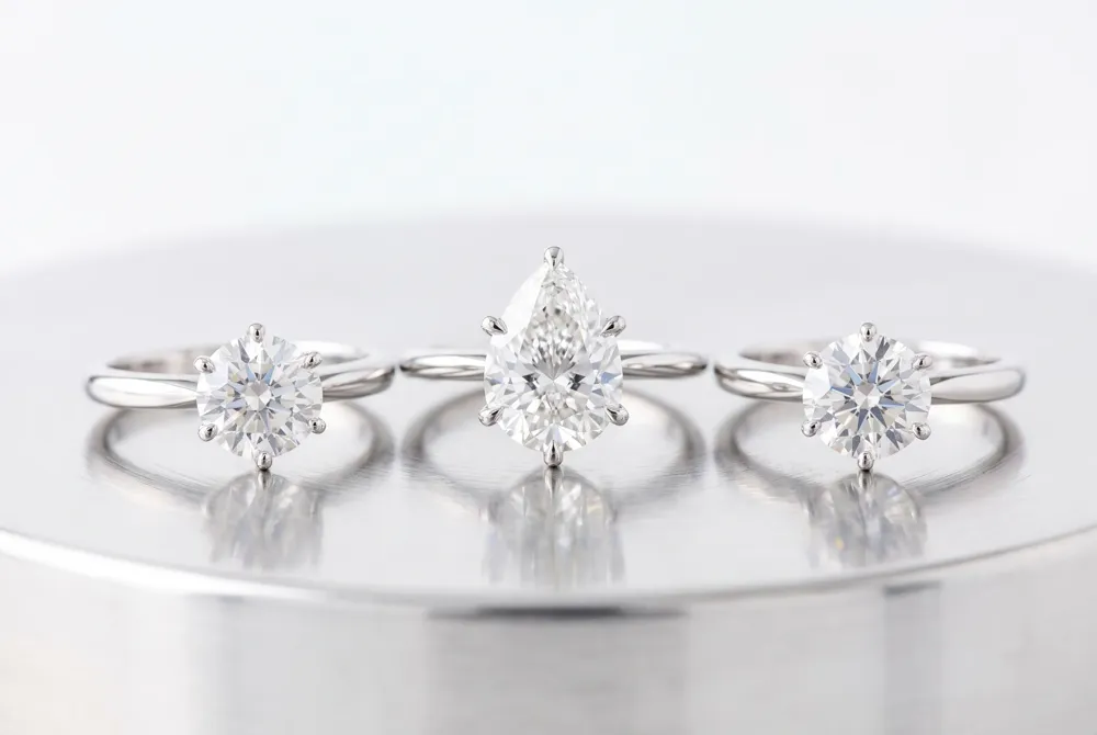 A three-stone arrangement places the pear at the center, flanked by two stones that tell a story of shared time.