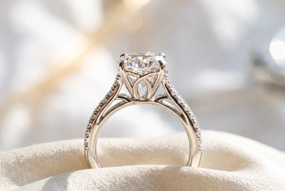 Soaring arches rise from the band to cradle the marquise diamond, creating an open, airy silhouette that allows light to pass beneath the stone for enhanced brilliance.