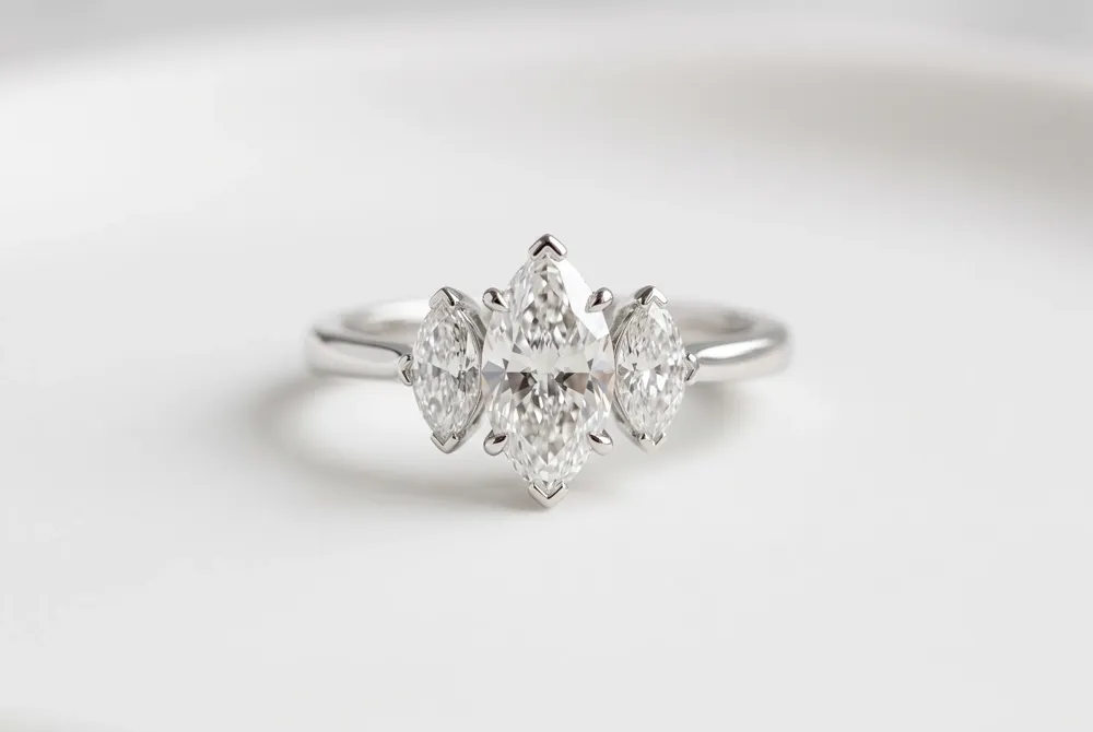 A marquise center takes the spotlight in a balanced trilogy setting, with protective prongs securing its delicate points.