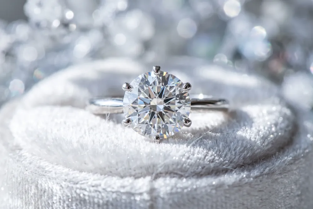 Crushed ice facets scatter light into a dreamy, frosted shimmer, while a hidden halo of tiny accent stones adds a subtle, romantic glow beneath the center stone's girdle.
