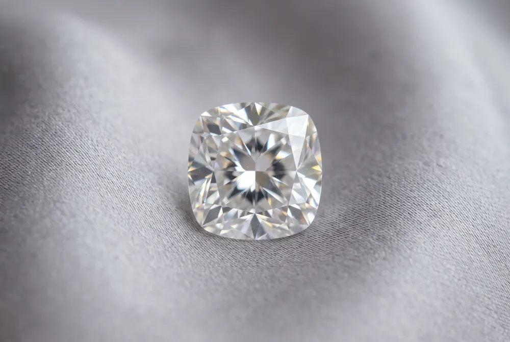 The cushion cut brings a romantic pillow-like silhouette to moissanite, a lab-created gemstone celebrated for its extraordinary brilliance and everyday durability.
