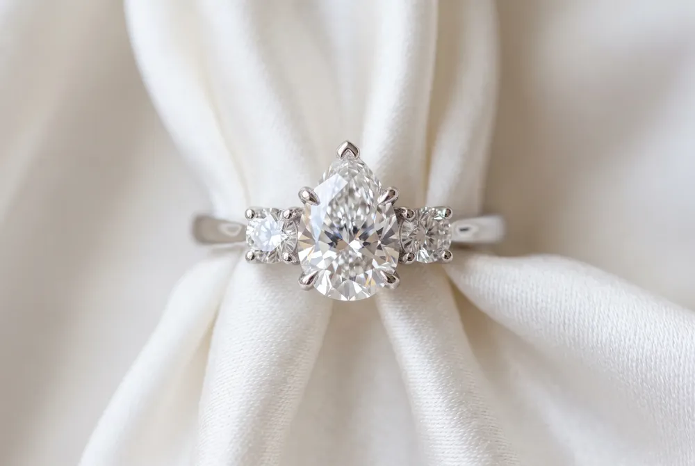 Three stones honor your love story, with the center pear representing your present and flanking diamonds celebrating the past and future.